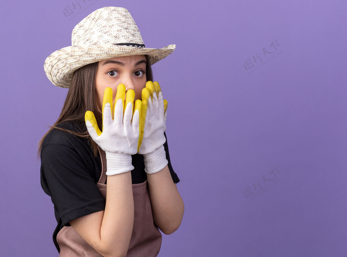 园艺震惊美丽的白人女园丁戴园艺帽子和手套把手放在嘴上女手套帽子