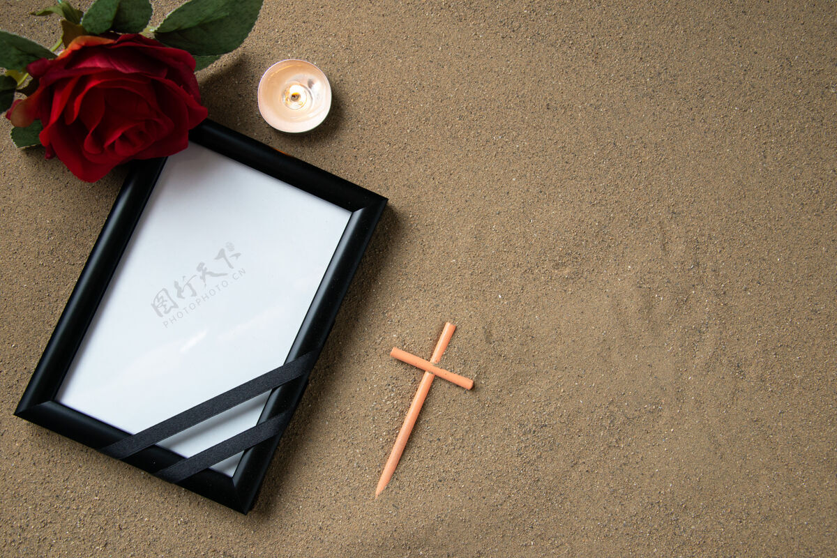 图片在沙滩上的红色花朵和画框棒十字架的顶视图纹理花沙子