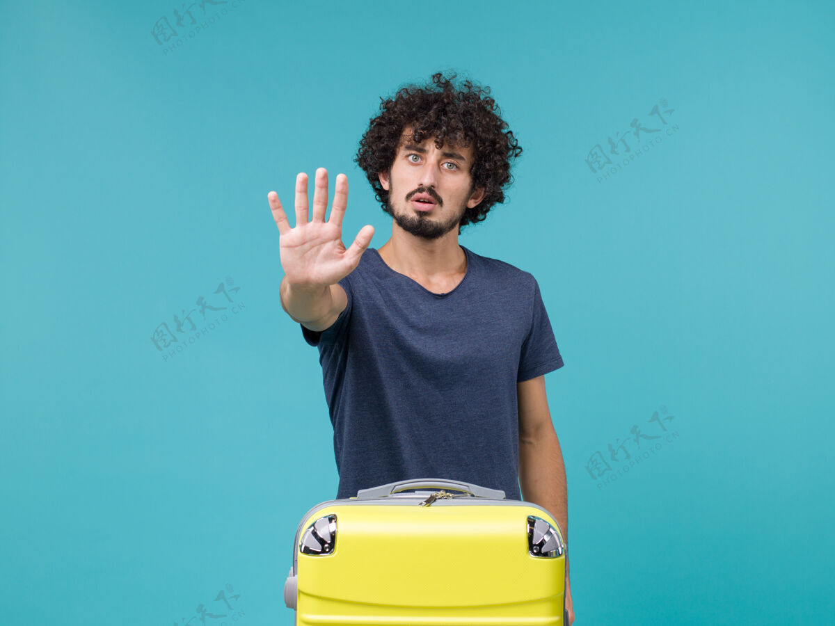 行李度假的男人把手掌放在蓝色上旅程蓝色男性