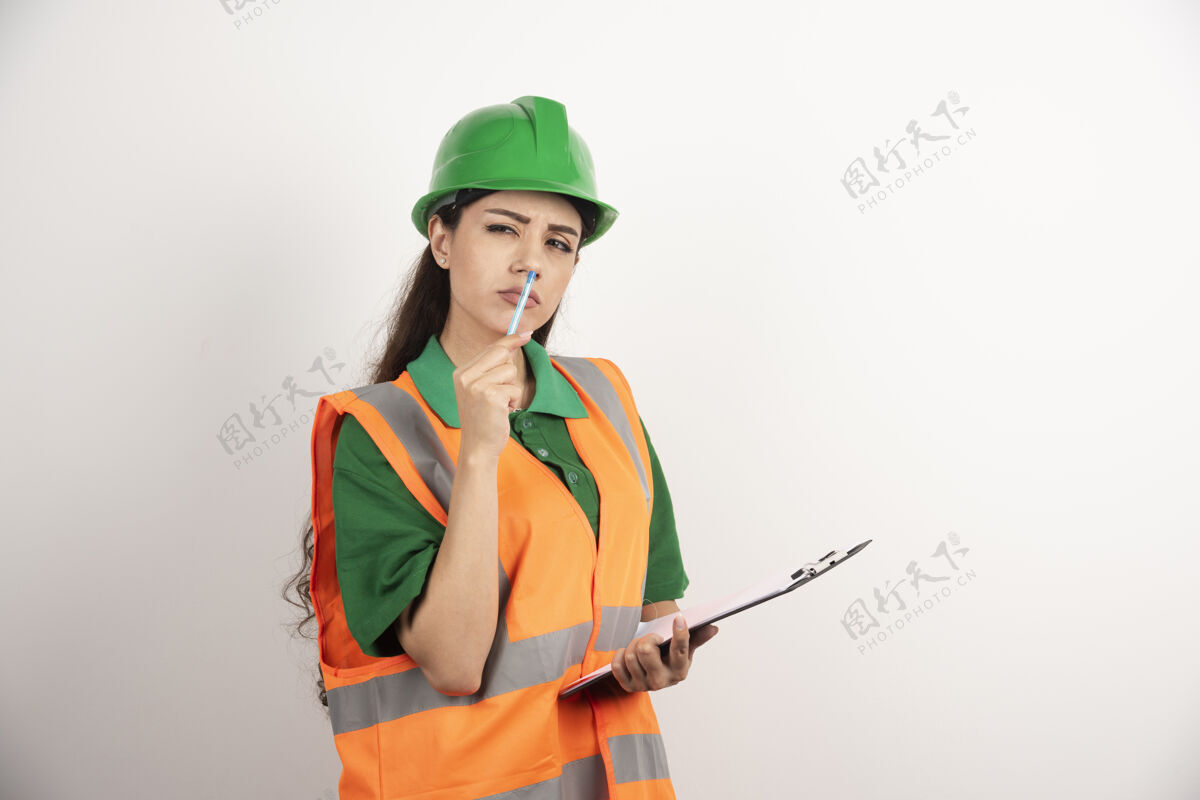 人认真的女工程师与剪贴板上的白色背景高品质的照片制服安全帽工程师