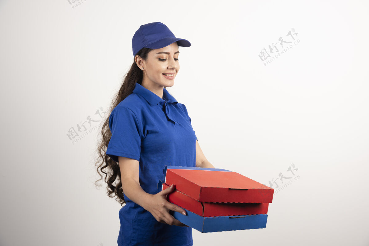制服身着蓝色制服的快乐微笑送货女孩 白色背景上有外卖披萨盒高质量照片年轻人职业服务