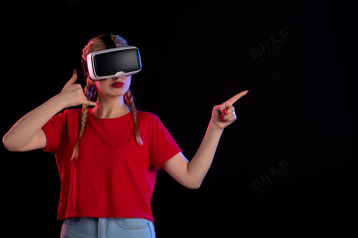 视图年轻女性在黑暗的墙上玩虚拟现实的正面图人虚拟现实视觉
