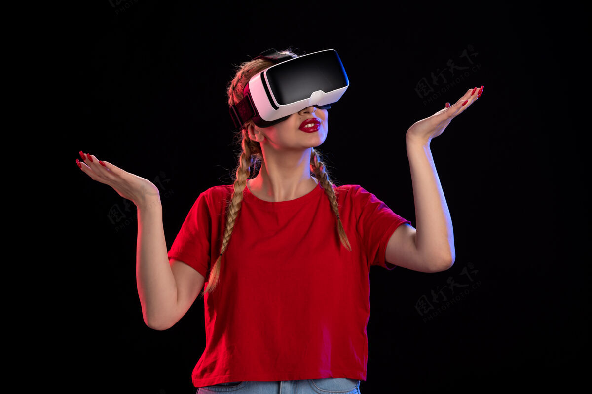 游戏年轻女性在黑暗的墙上玩虚拟现实的正面图虚拟现实年轻女性视觉
