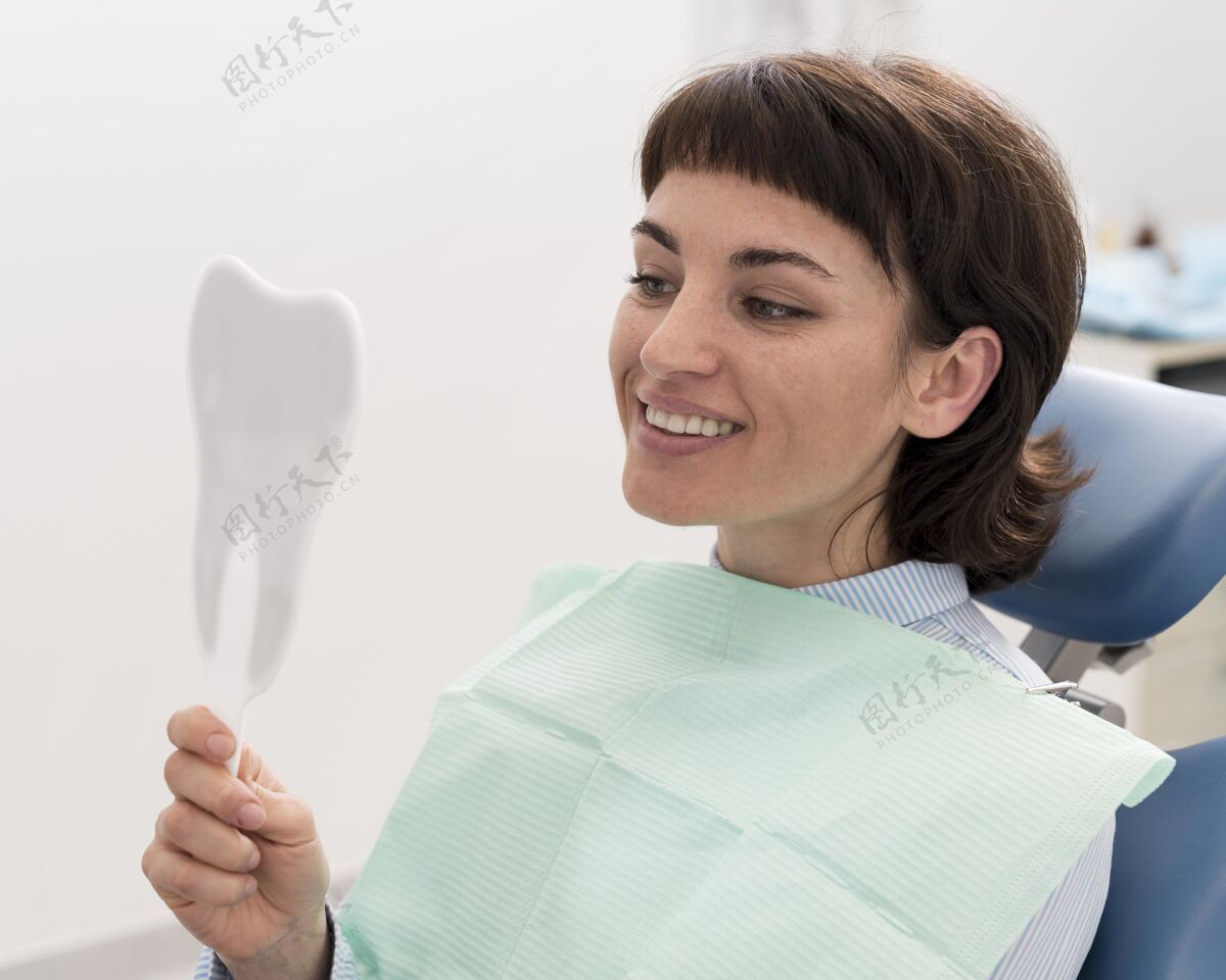 横向牙科手术后照镜子的女病人工作职业正畸医生