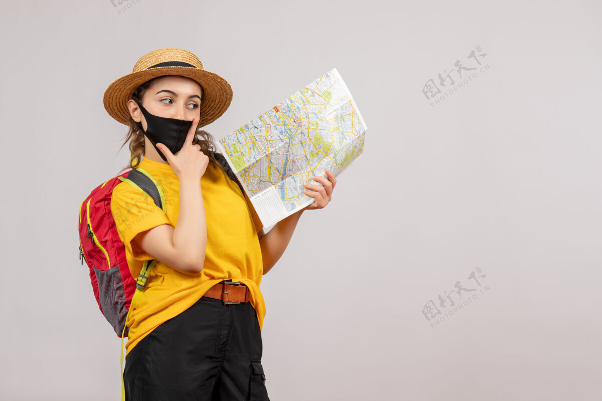 可爱带着背包的体贴的年轻旅行者举着灰色的地图地图灰色时尚