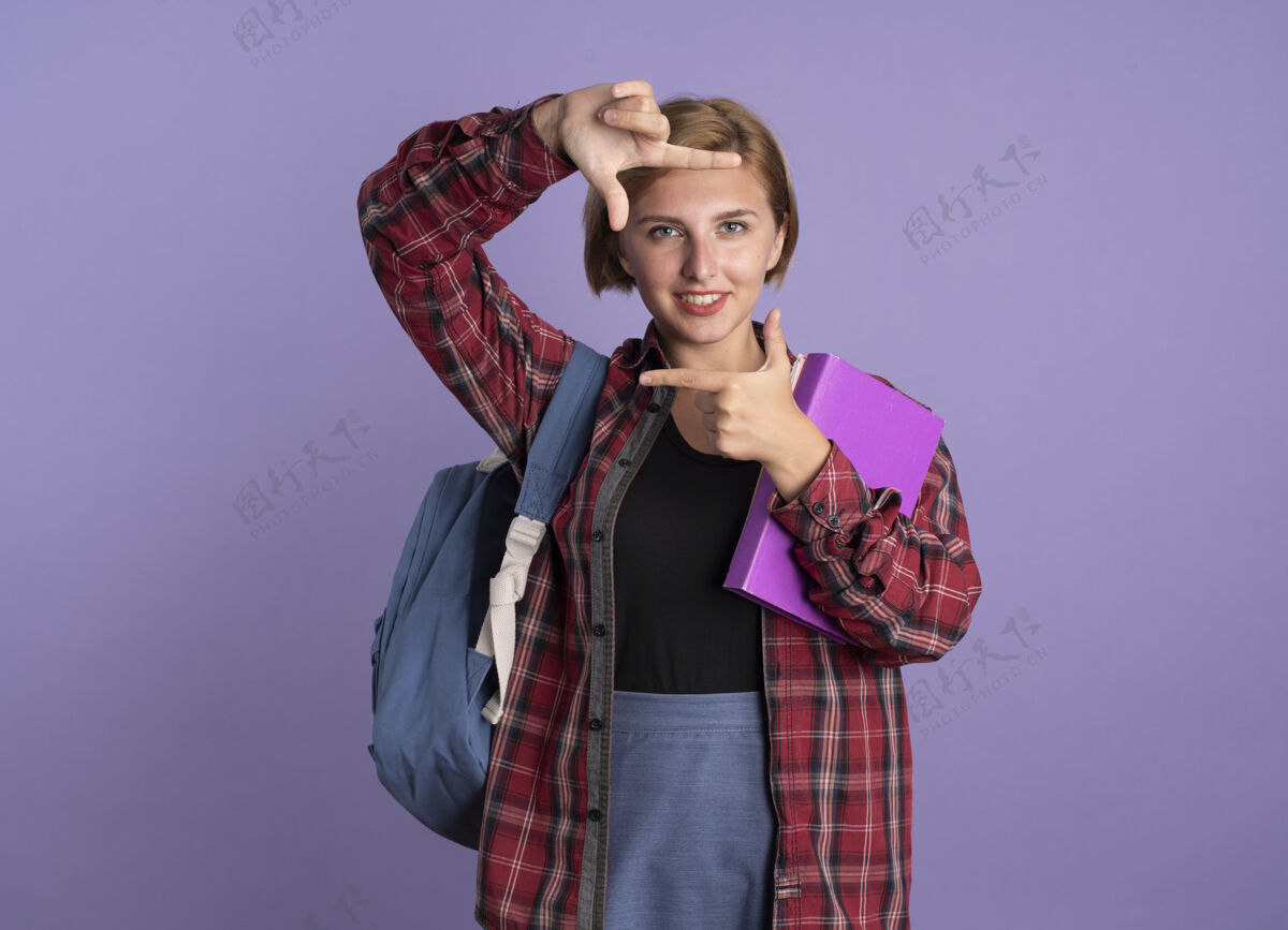 学生面带微笑的年轻斯拉夫女学生 背着背包 手拿着书和笔记本背包框架紫色