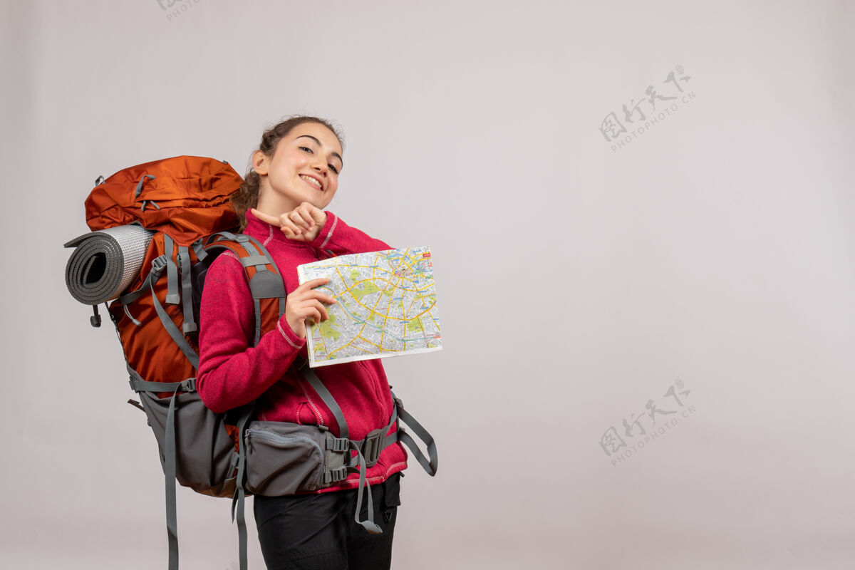灰色微笑着的年轻旅行者 背着大背包 手里拿着灰色的地图成人肖像人