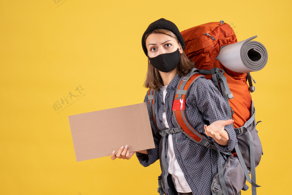 成人一个带着黑色面具 背着硬纸板的背包的旅行女孩男人纸板黑色