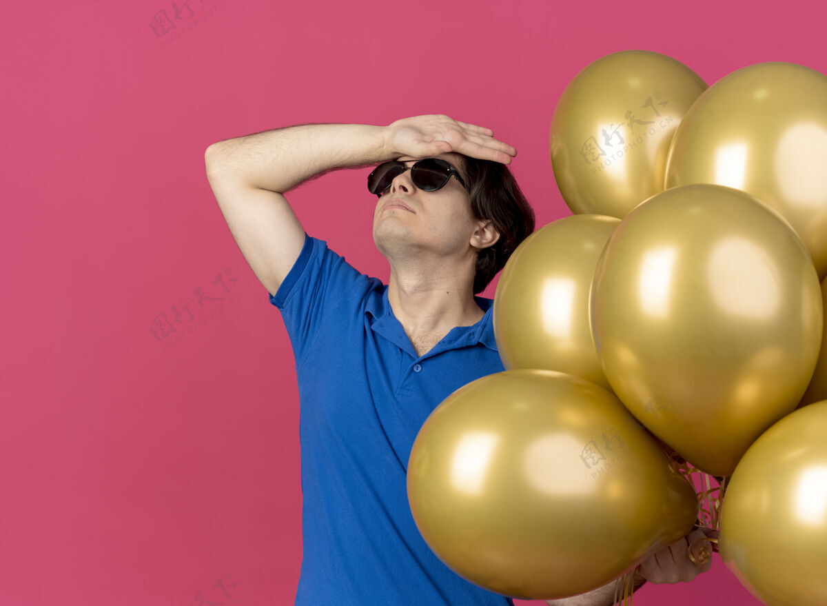 粉色一个戴着太阳眼镜的白人帅哥拿着氦气球 把手放在额头上眼镜帅哥气球