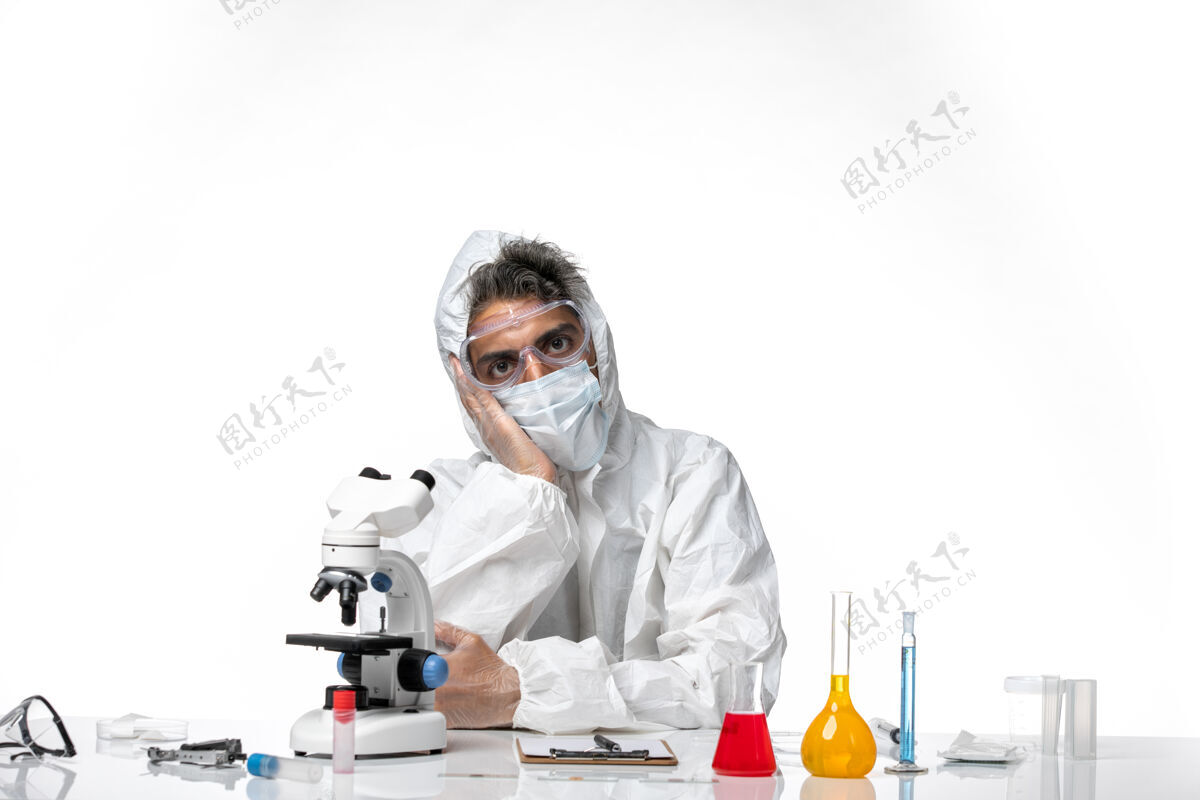 坐着正面图：男医生穿着防护服 戴着无菌口罩 坐在白色的椅子上病毒大流行实验室