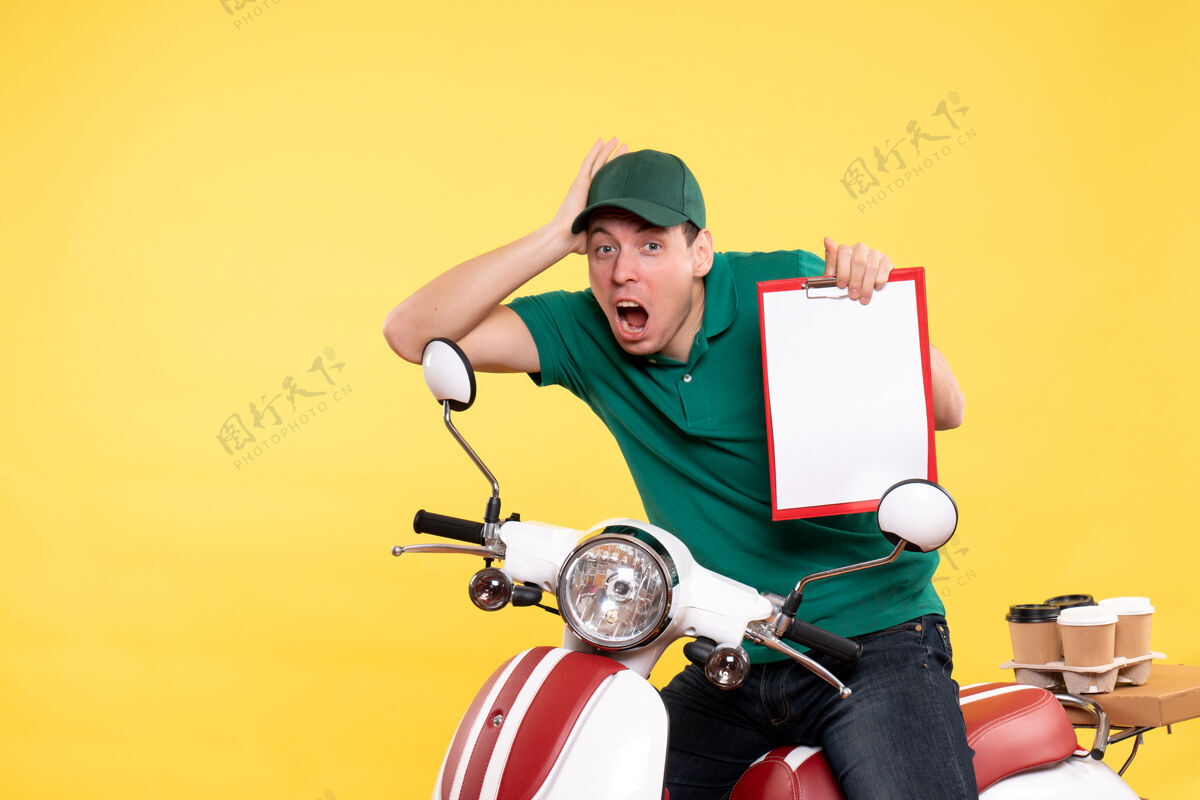 食物正面图身穿绿色制服的年轻男信使拿着黄色的文件纸条文件便条摩托车