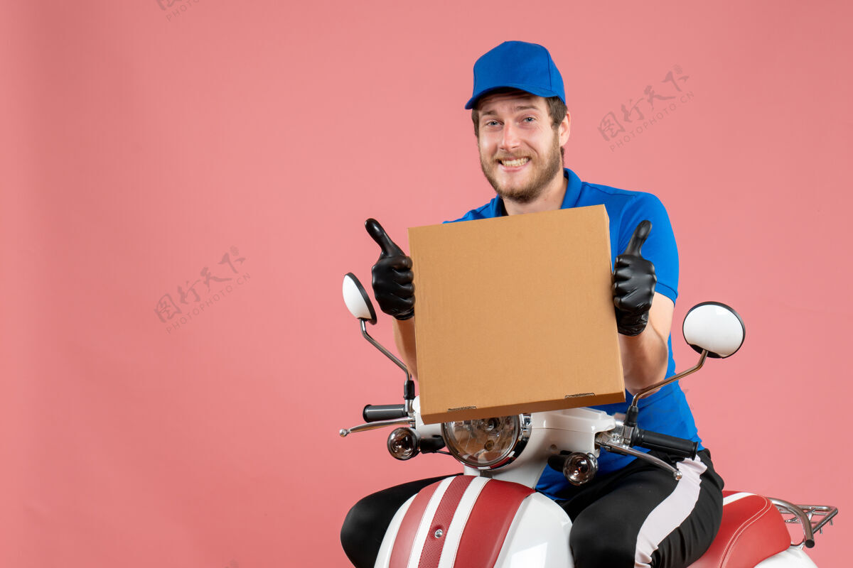 工人正面图男性信使坐在自行车上 拿着粉红色的比萨饼盒举行披萨盒子