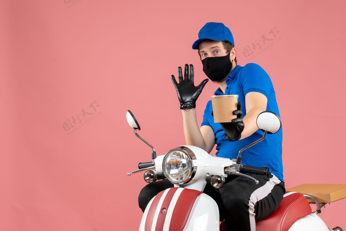 男信使正面图男性信使坐在自行车上 拿着粉红色的大咖啡杯坐着送货工作
