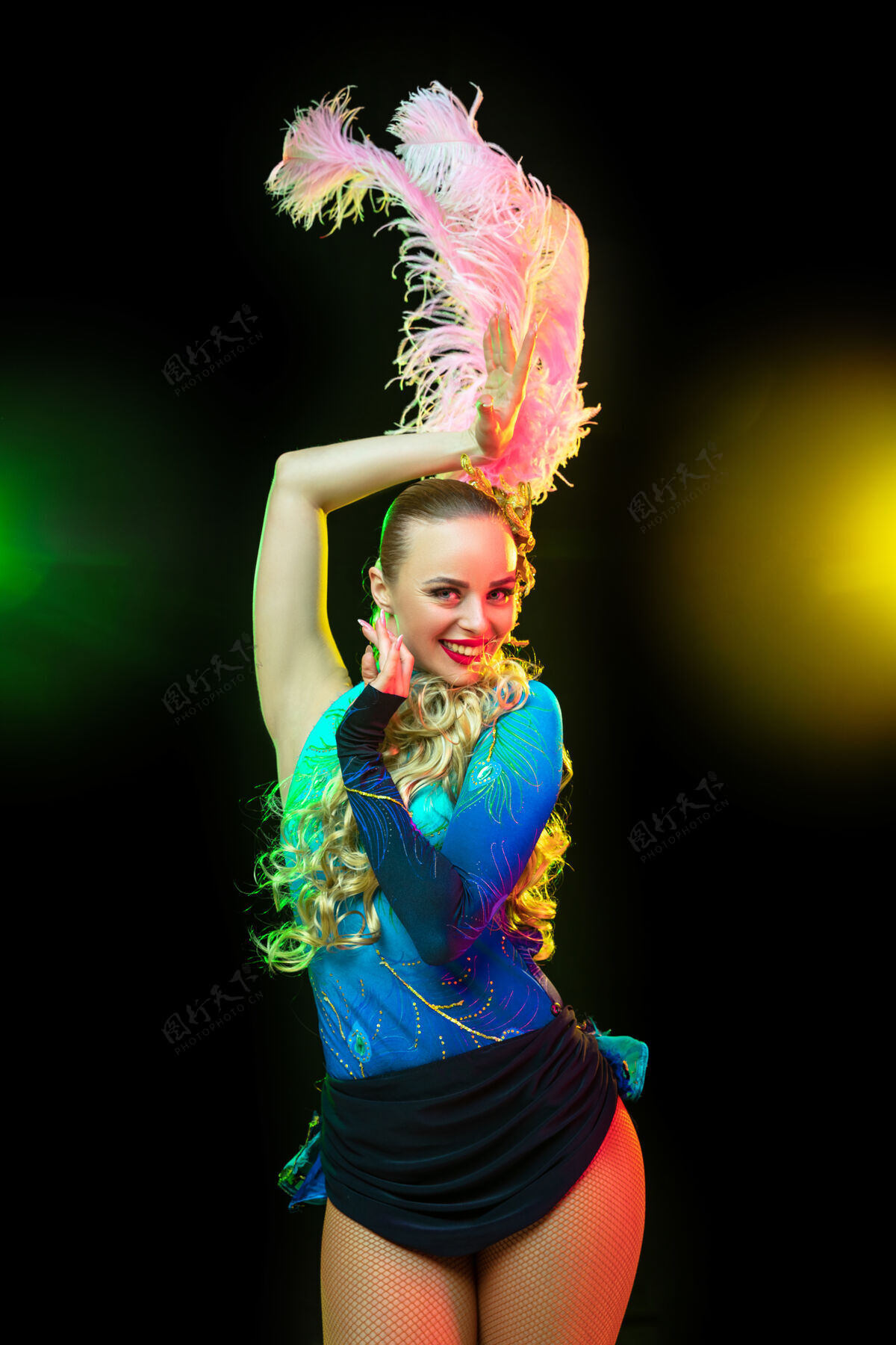 巴西嘉年华里美丽的年轻女子 霓虹灯下黑色墙壁上羽毛的时尚化装服装马尔迪河流脸