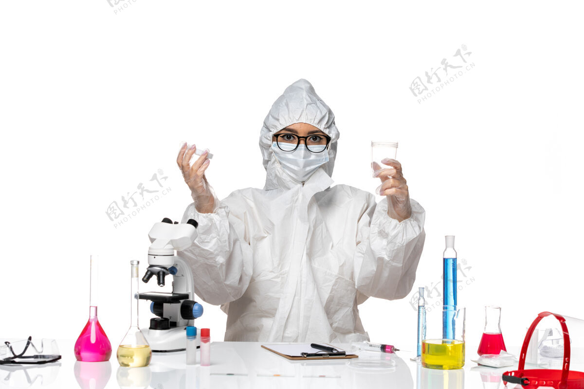 特殊正面图身穿特殊防护服的年轻女化学家拿着装有溶液的烧瓶 在白色背景上写着实验室冠状病毒化学病毒人保持医疗