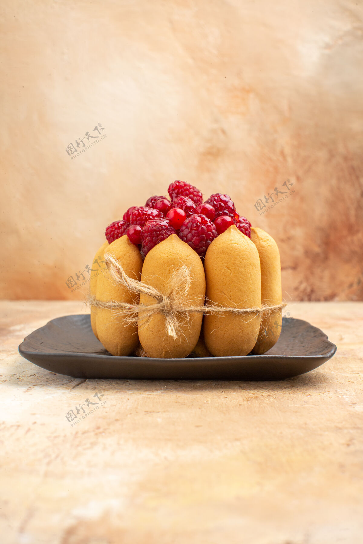 小吃咖啡和茶时间的礼品蛋糕的垂直视图 棕色托盘上有覆盆子甜瓜浆果覆盆子