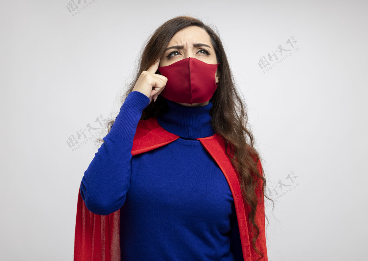 面具困惑的高加索超级英雄女孩穿着红色斗篷戴着红色的防护面具斗篷太阳穴困惑