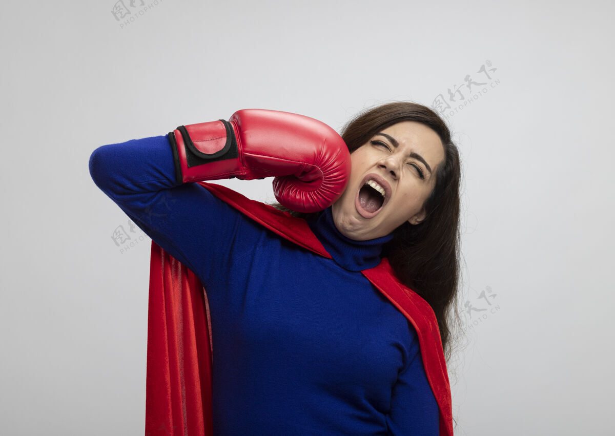 手套恼怒的高加索超级英雄女孩穿着红色斗篷戴拳击手套拳击斗篷假装