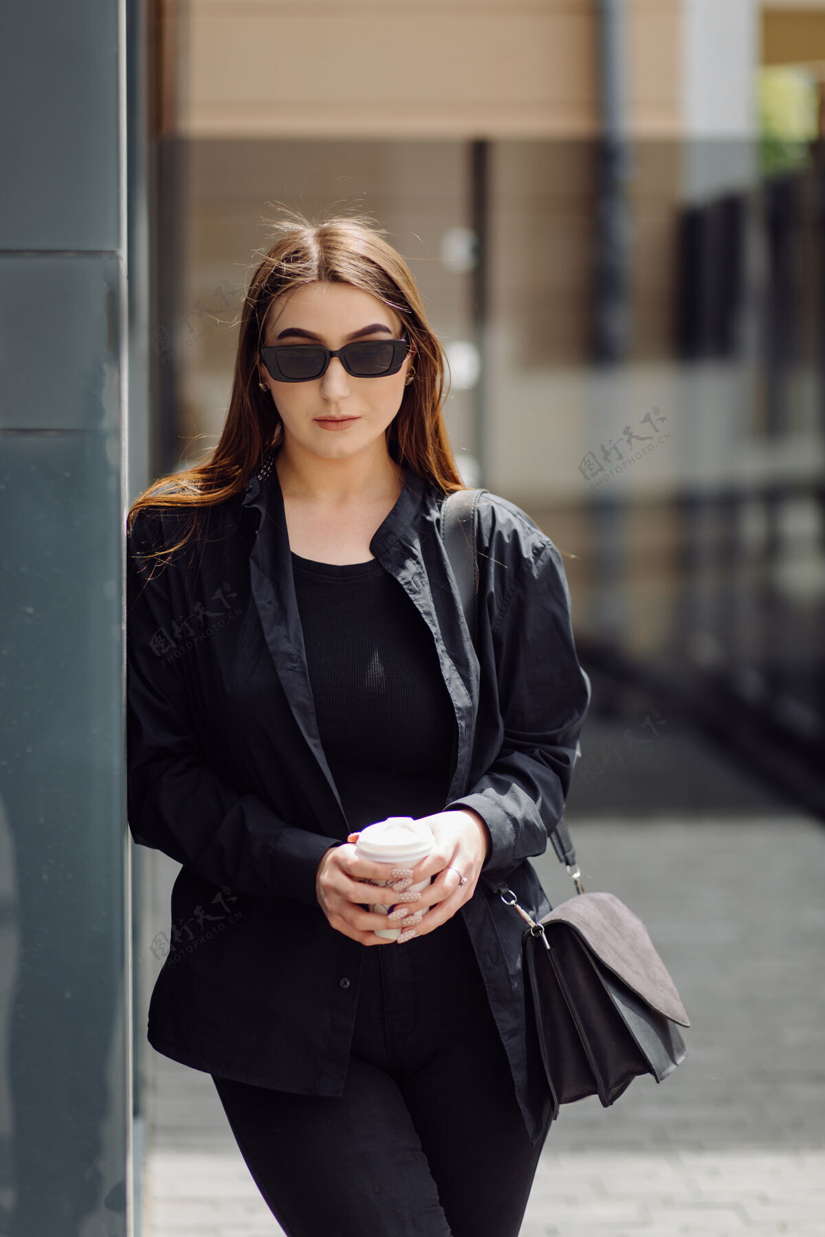 杯子户外生活写真迷人的黑发女孩喝咖啡 走在城市街道上夹克秋天太阳镜