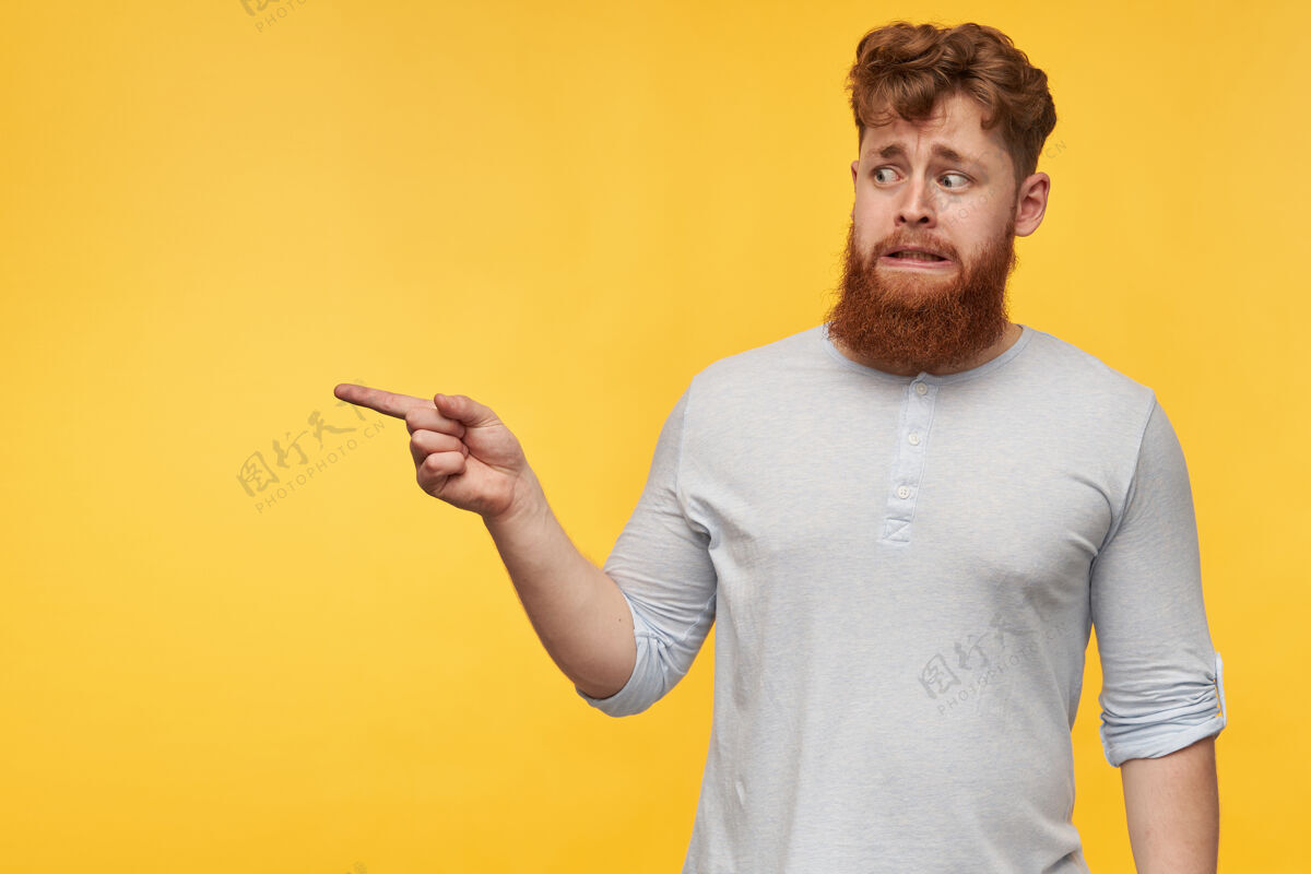 学生一个留着大胡子的年轻红发男人 感到恼怒和困惑 用手指指着一个拷贝空间红发厌恶年轻