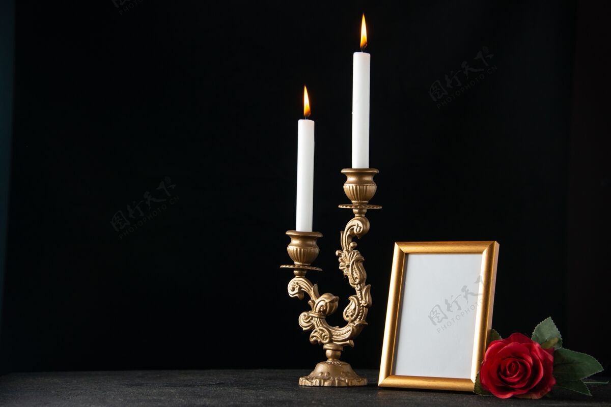 烛台前视图燃烧蜡烛与图片框在黑暗的表面火正面框架