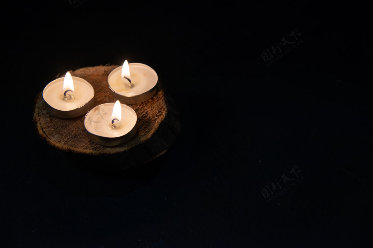 火在漆黑的表面燃烧蜡烛的正面图火焰蜡烛死亡