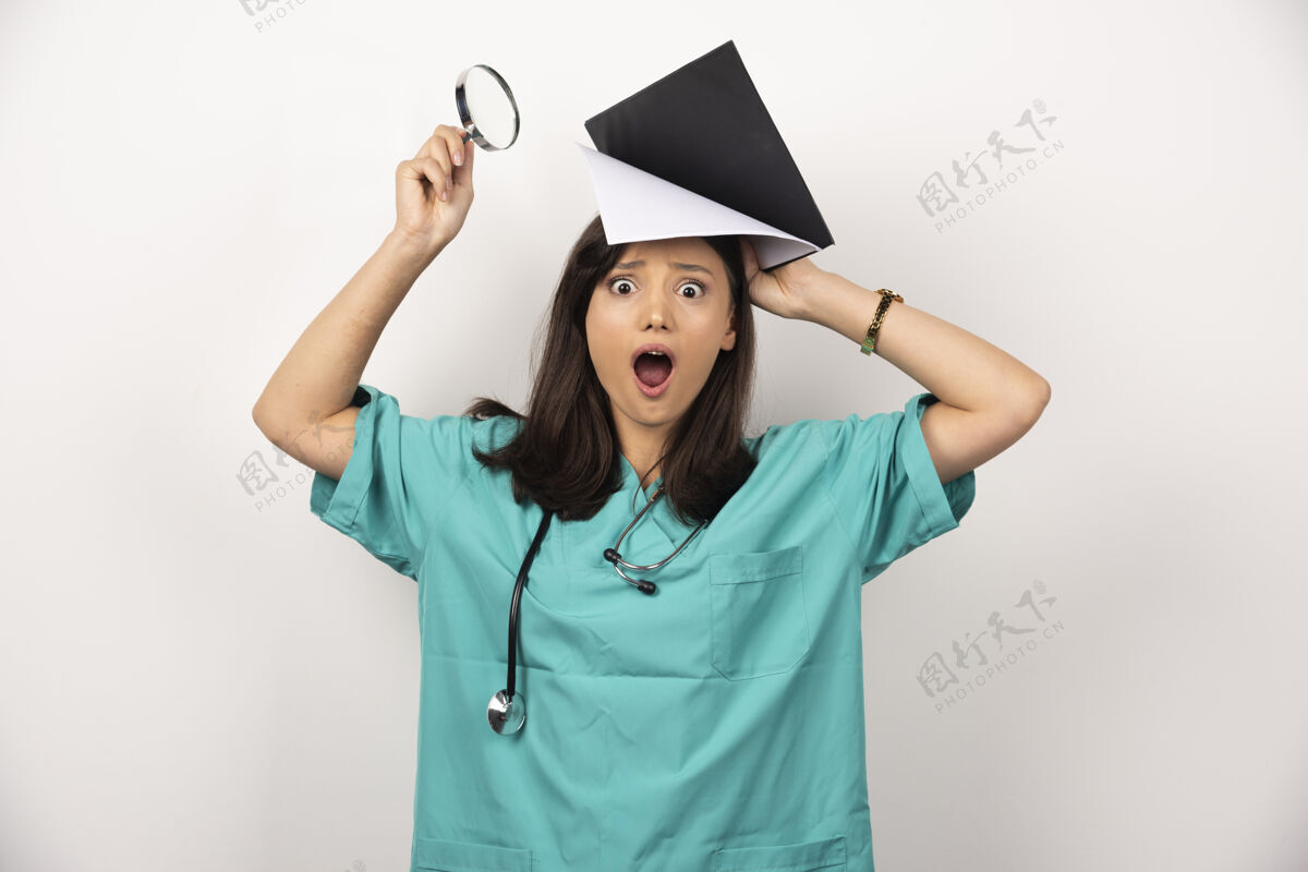 女性惊讶的医生拿着放大镜和剪贴板在白色背景上高质量的照片职业女士工作