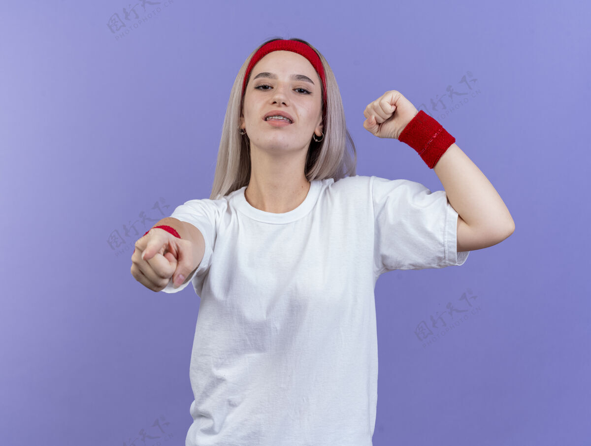 自信自信的年轻白人运动女孩戴着背带和头带二头肌背带尖