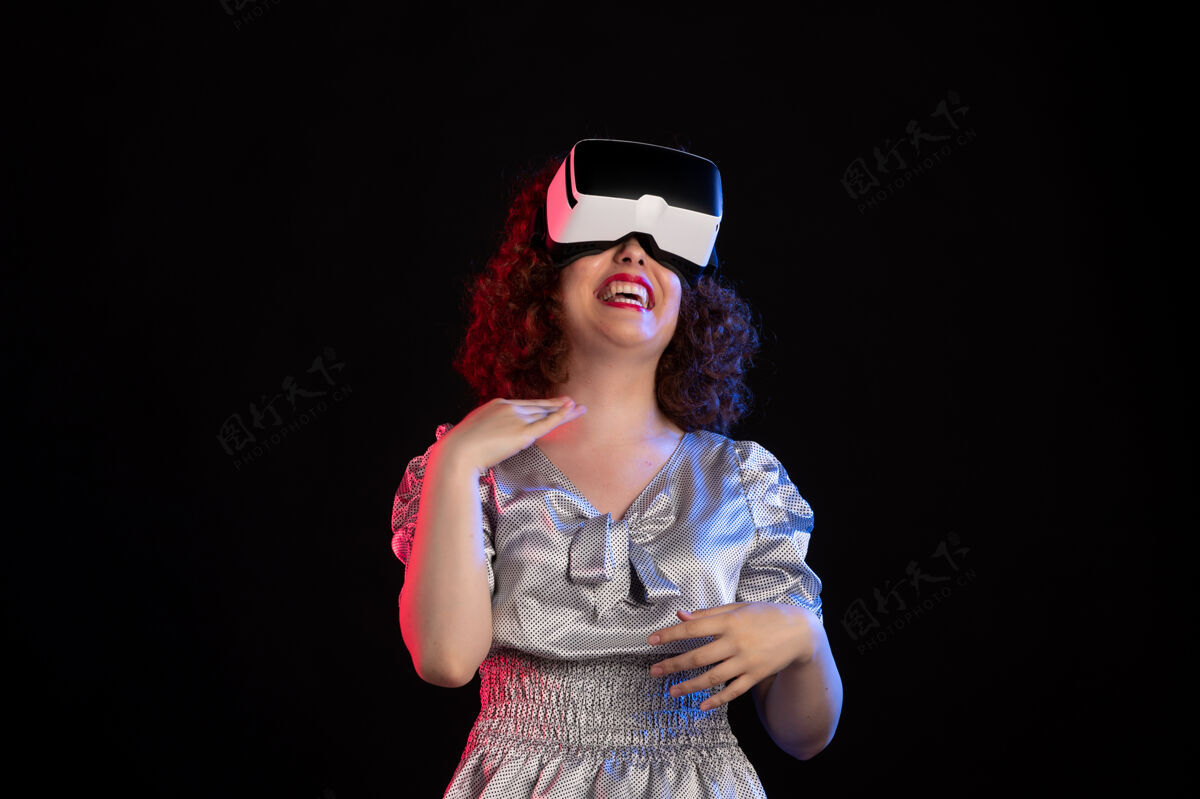 虚拟年轻女性戴着虚拟现实耳机在黑暗的表面黑发女人成人