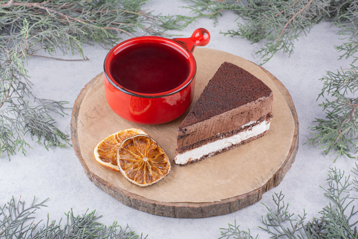 慕斯慕斯蛋糕 橘子片和一杯茶放在木片上美味巧克力块