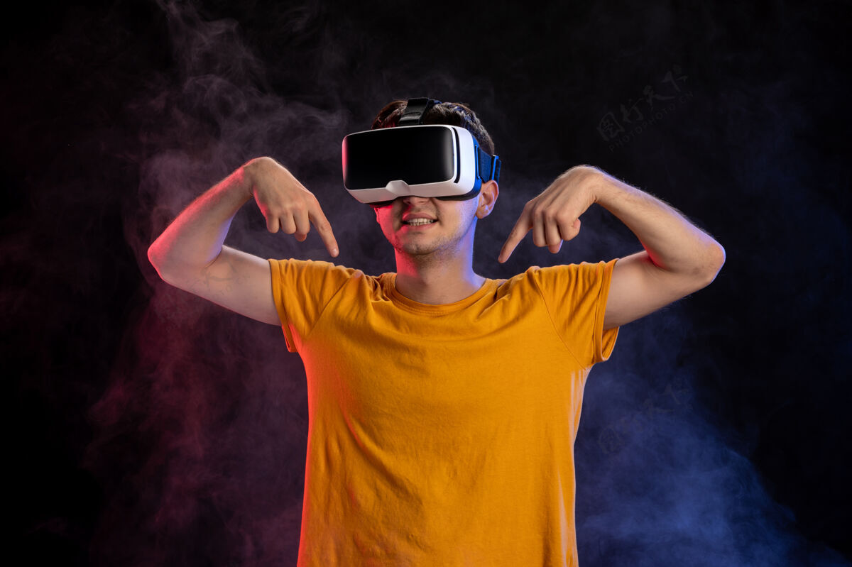 人帅哥戴着虚拟现实耳机在黑暗的表面视觉成人现实