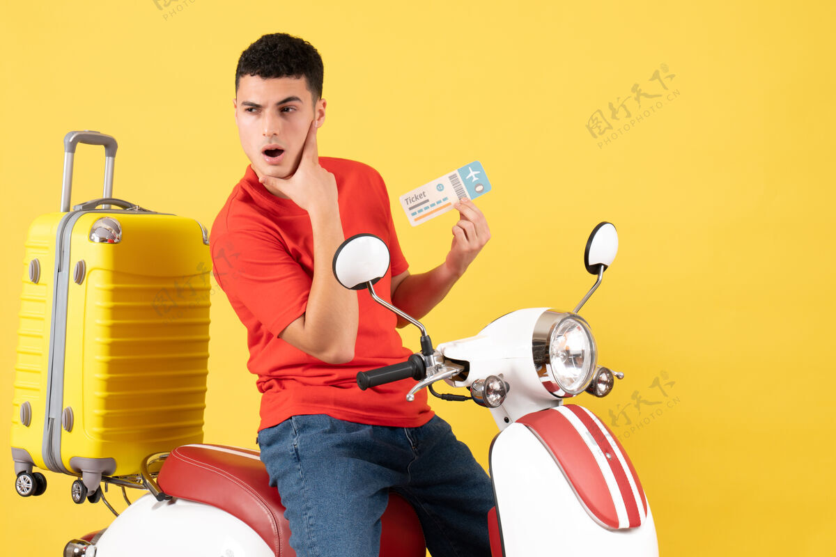 年轻男性正面图年轻男子穿着休闲服 手持轻便摩托车入场券视图前排成人