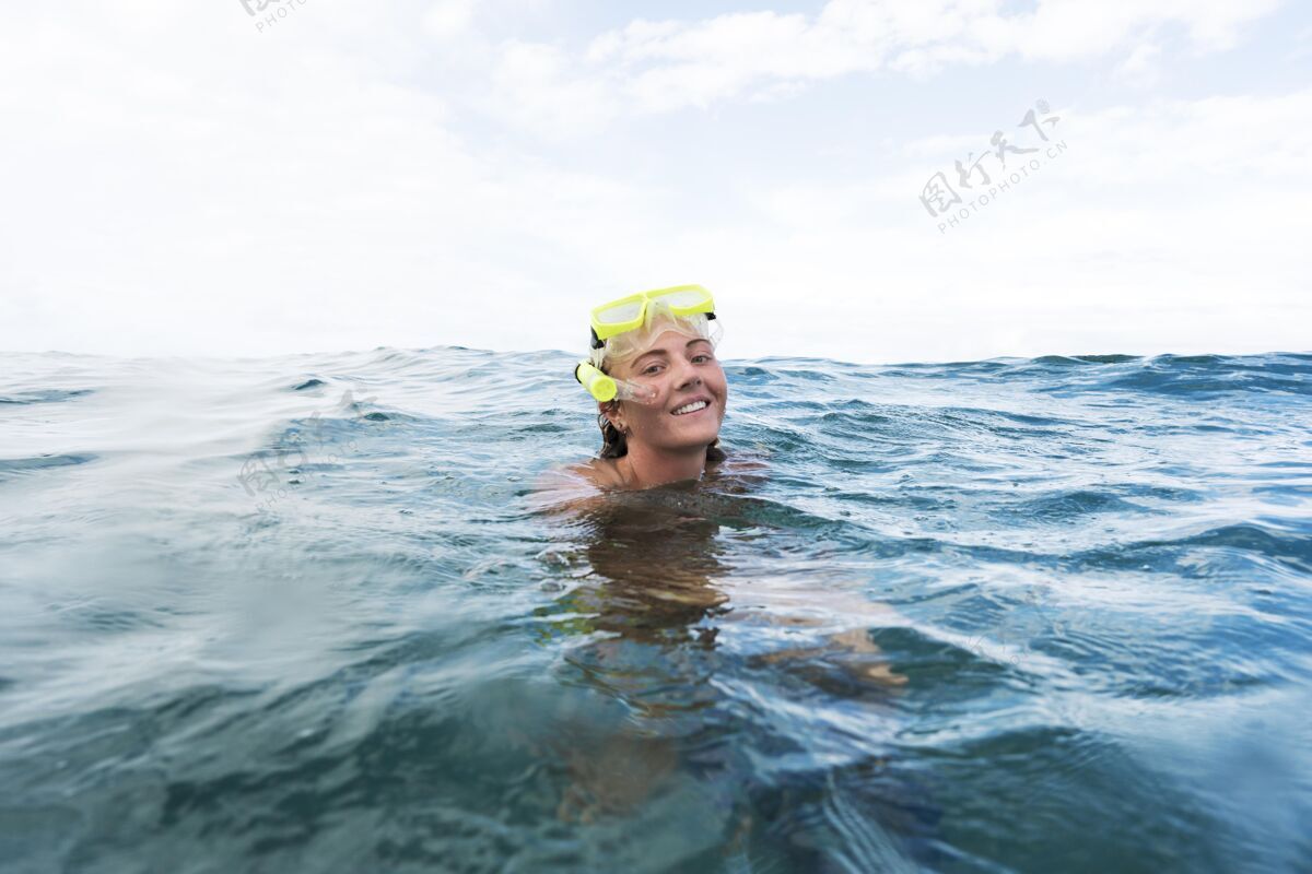 水戴着潜水器在海里游泳的女人水上游泳潜水
