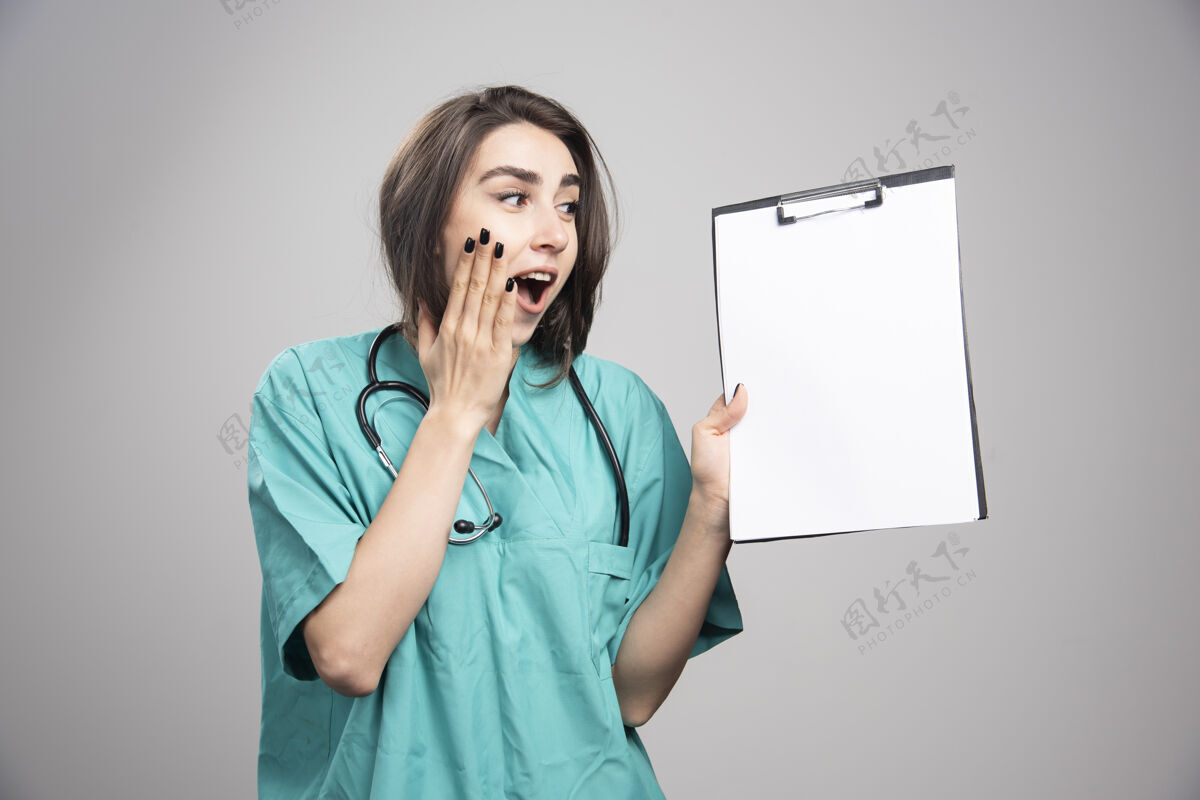 成人惊讶的医生显示在灰色背景剪贴板高质量的照片职业疾病肖像