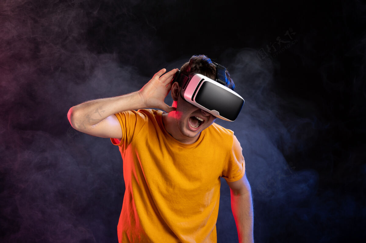 男性帅哥戴着虚拟现实耳机在黑暗的表面视觉现实设备