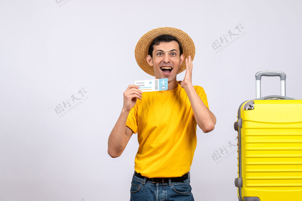 欢呼正面图年轻的游客拿着票站在黄色手提箱旁表达自己的感受人票表达