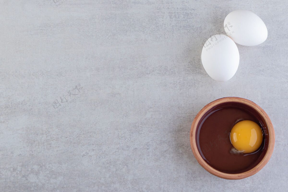 未煮熟的把新鲜的生鸡蛋放在石头桌上鸡蛋生的未经料理的