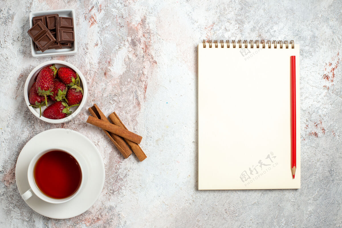 浆果一杯茶的顶视图与肉桂浆果在一个白色的表面肉桂水果茶杯