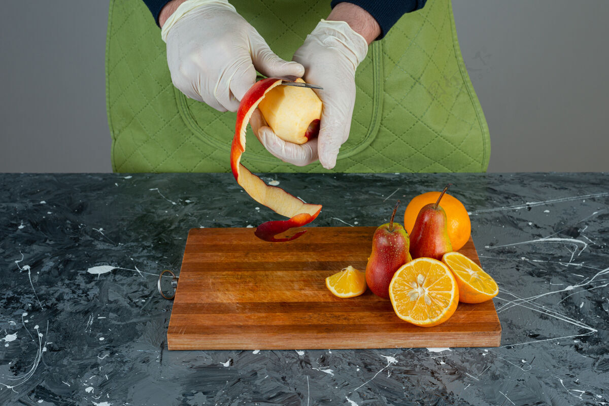厨师男人戴着手套在大理石桌上剥红苹果手各种烹饪