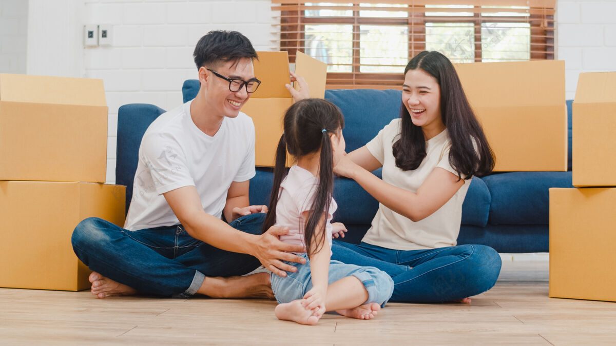 房子快乐的亚洲年轻家庭业主在新的房子欢笑夫妇隐藏