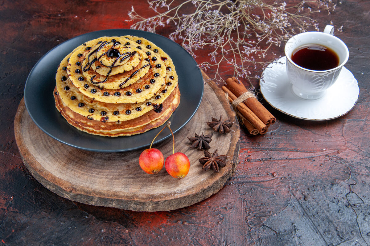 早餐前视图美味的甜煎饼和一杯茶在黑暗的背景甜点提神深色