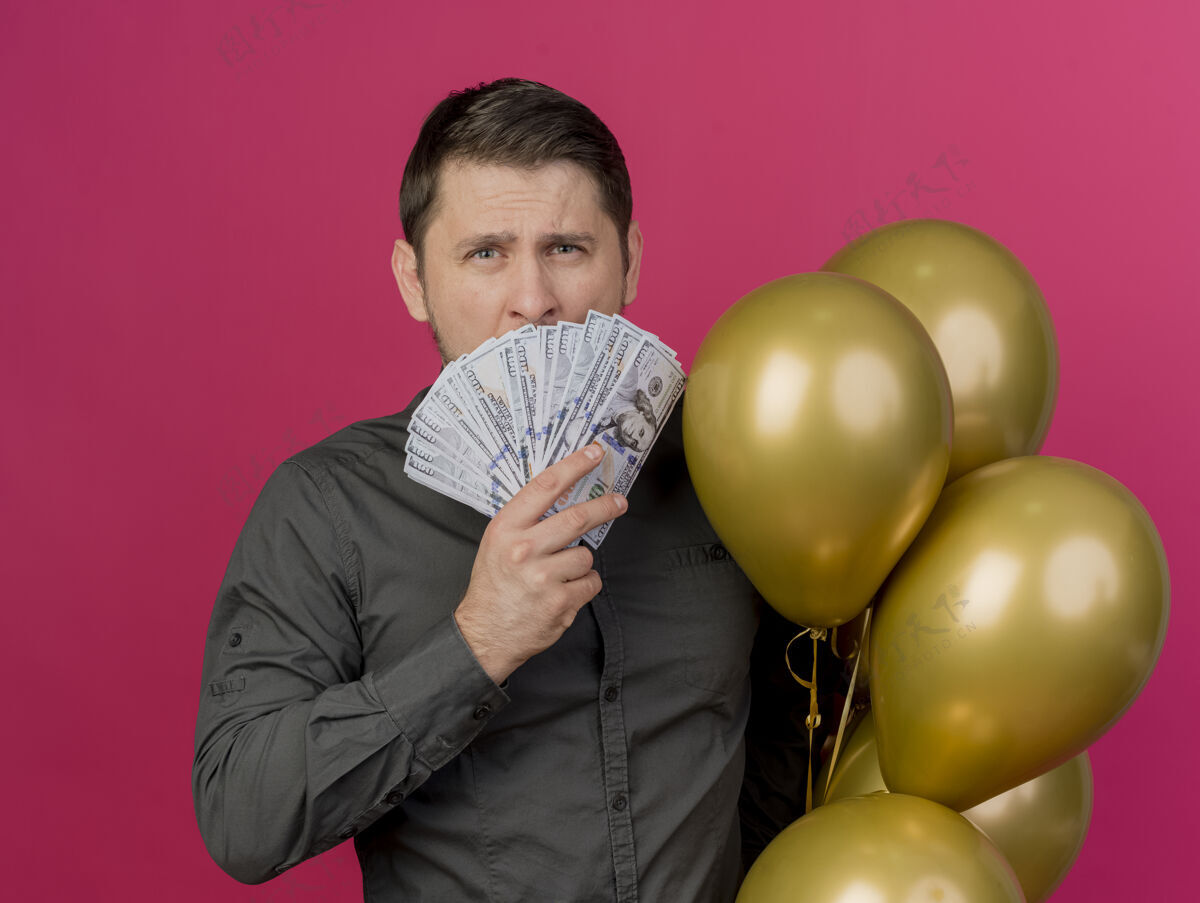 气球年轻的派对小伙穿着黑色衬衫拿着气球脸上贴着现金孤立的粉色粉色持有脸