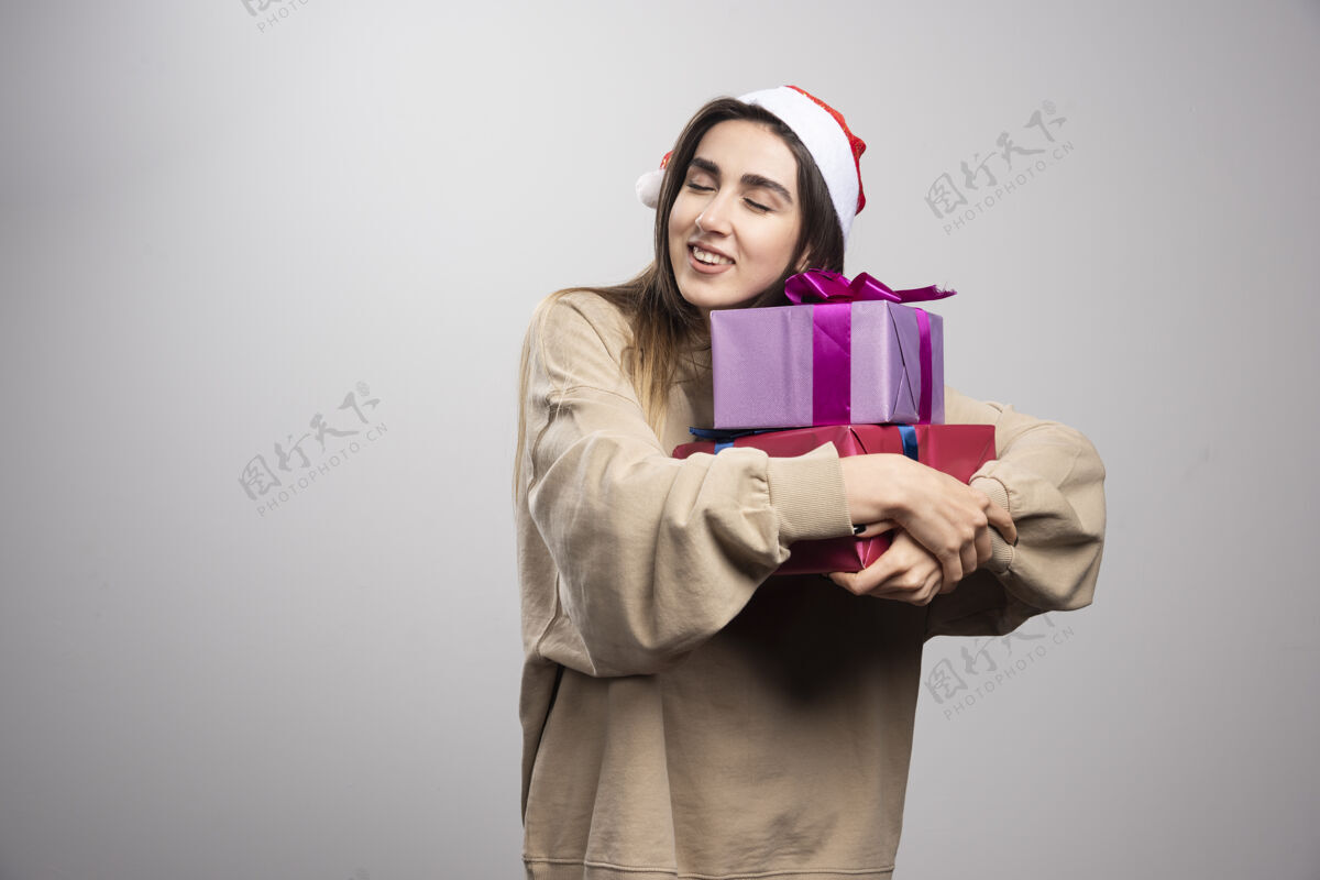 圣诞老人年轻女子抱着两盒圣诞礼物年轻成人礼物