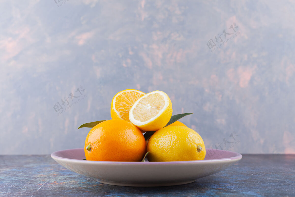 柑橘整片柠檬和切片的叶子放在石桌上美味食物切片
