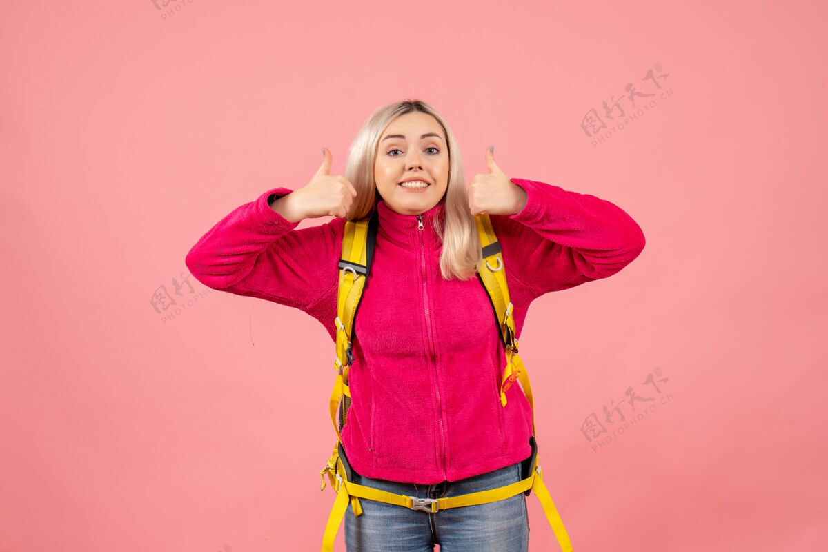 正面正面图黄色背包的女游客竖起大拇指赠送快乐风景
