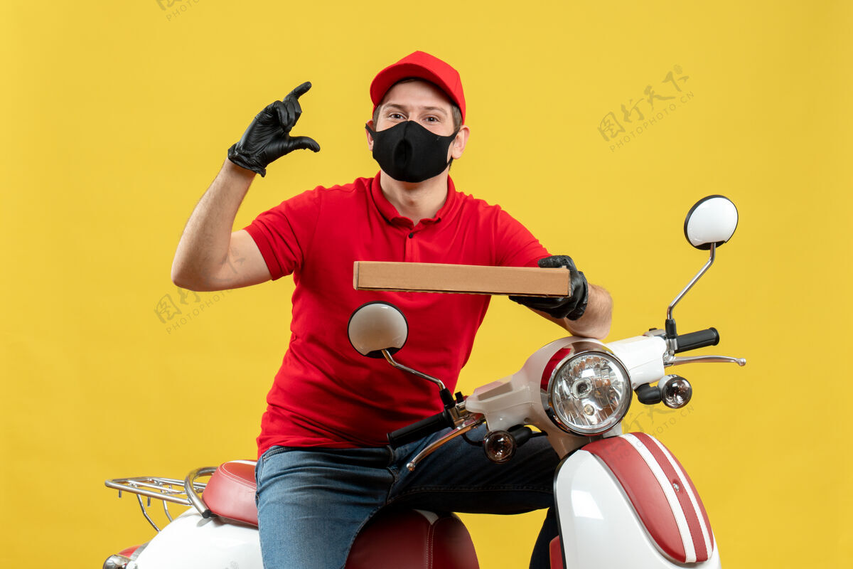 制造顶视图的快递员身穿红色上衣 戴着帽子手套 戴着医用口罩 坐在滑板车上 显示订单正在进行摩托车东西红色