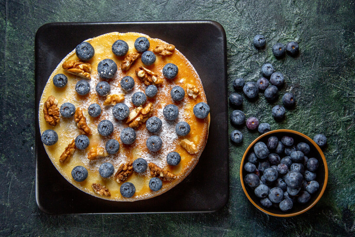 视野顶视图美味的蜂蜜蛋糕与蓝莓和核桃内板黑暗的表面浆果食物深色