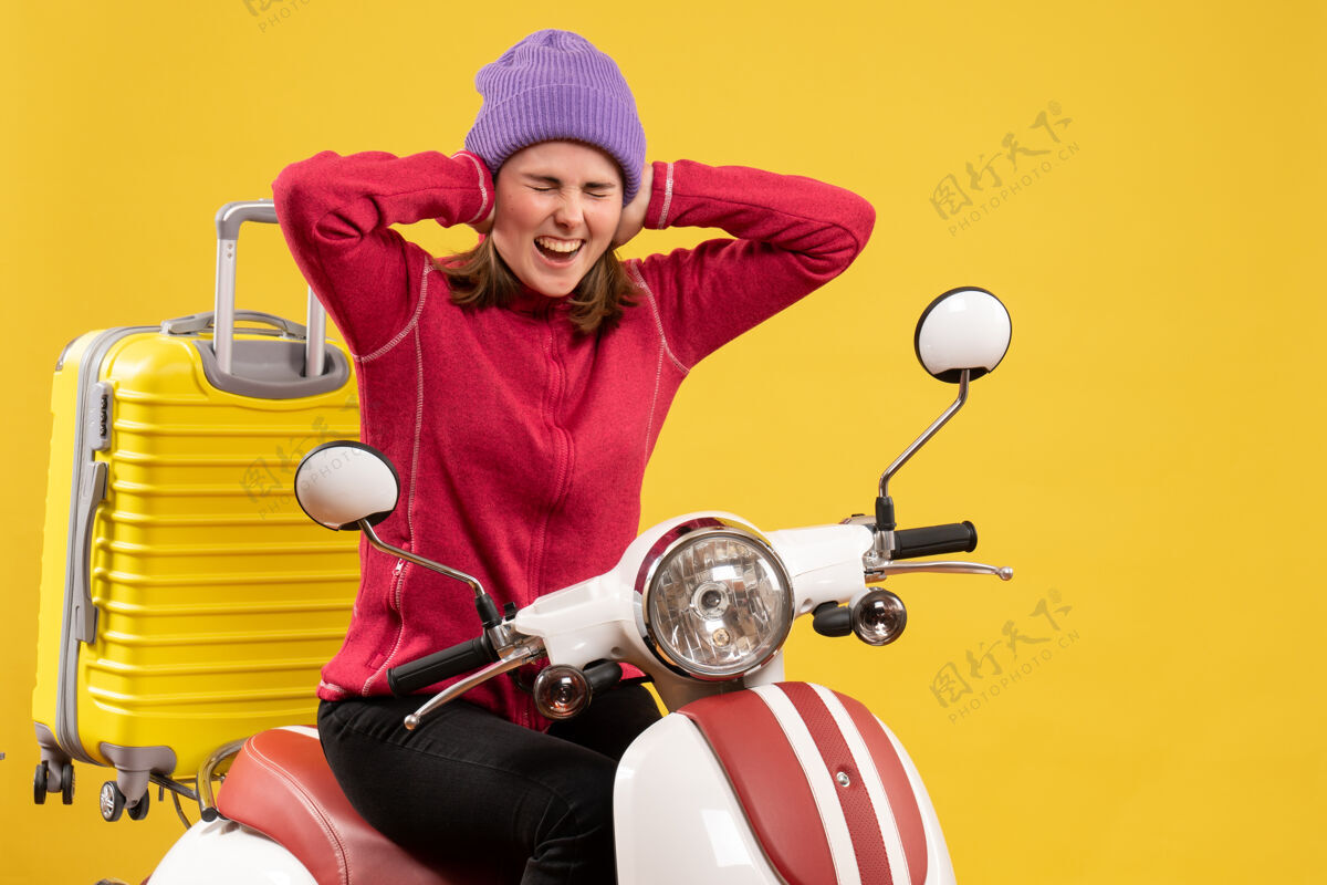 快乐前视图紧张的小女孩坐在轻便摩托车上闭着耳朵耳朵微笑人