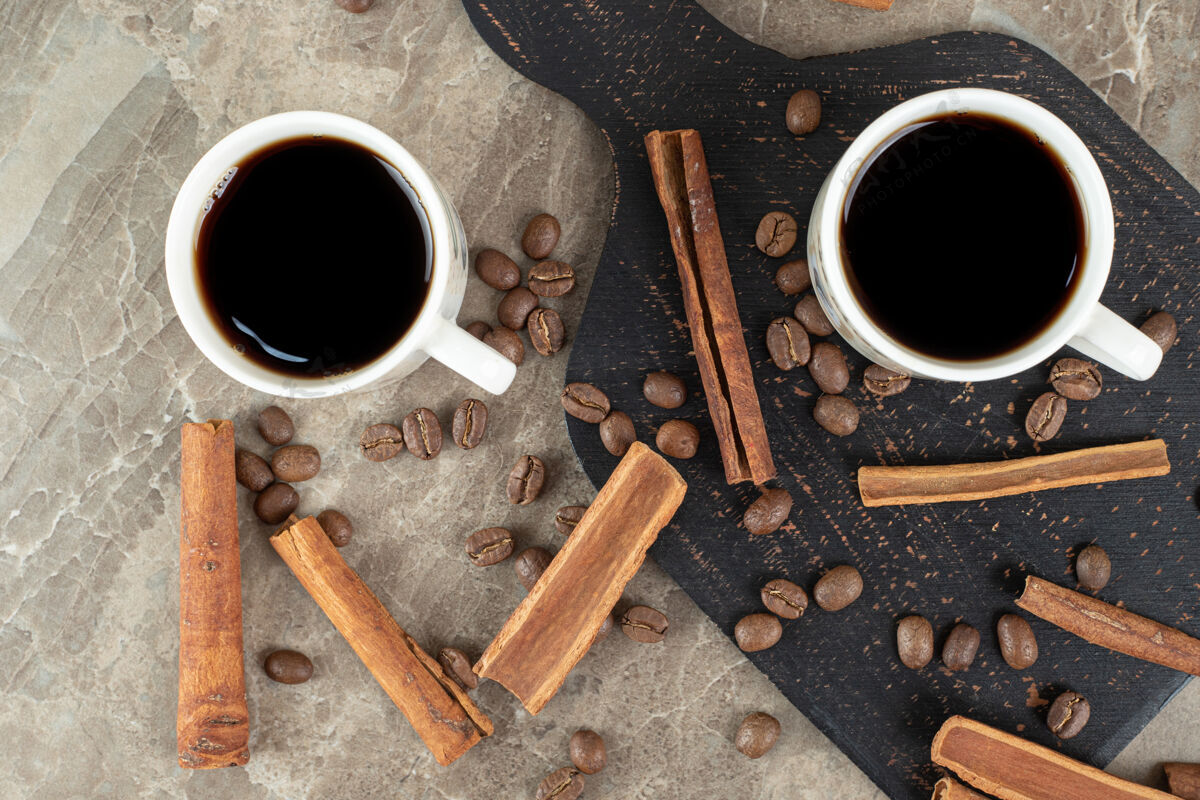 热浓缩咖啡 肉桂棒和咖啡豆在大理石表面棒咖啡因香味
