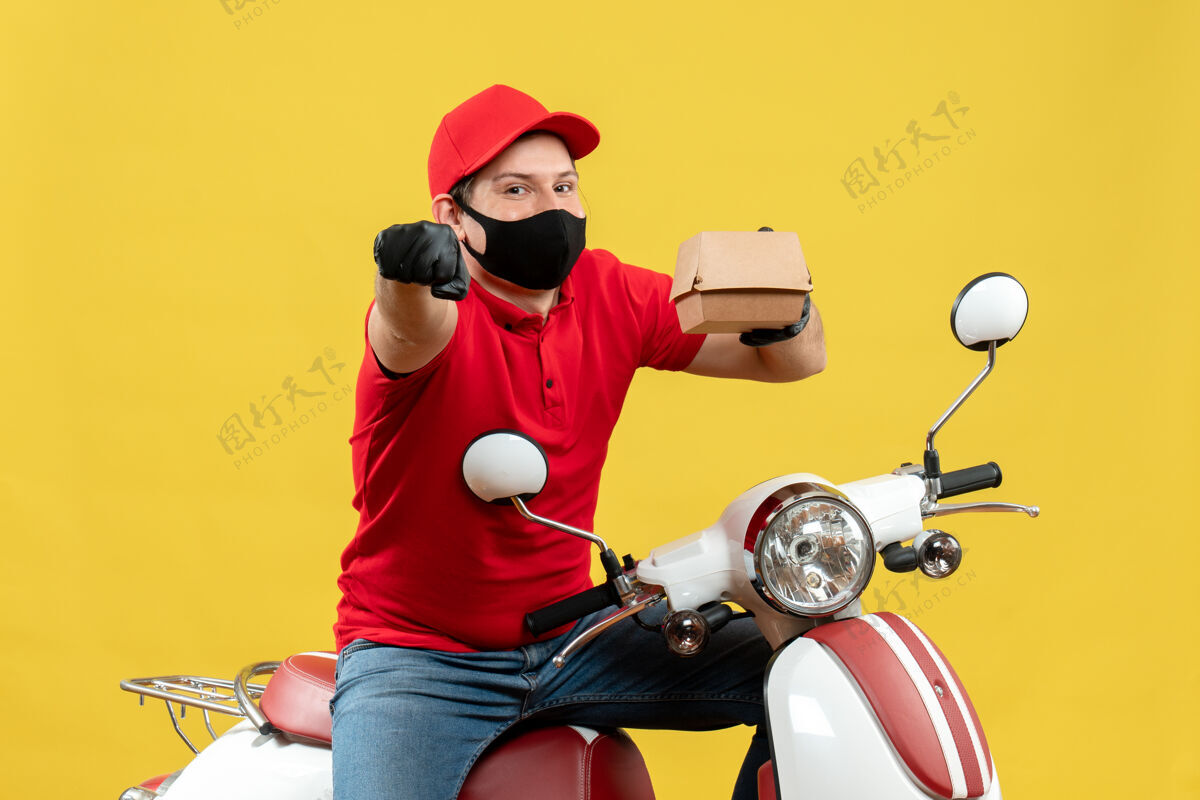 摩托车苏密林送货员身穿红色上衣 戴着帽子手套 戴着医用面罩 坐在滑板车上的俯视图 显示订单指向前方摩托车车辆坐
